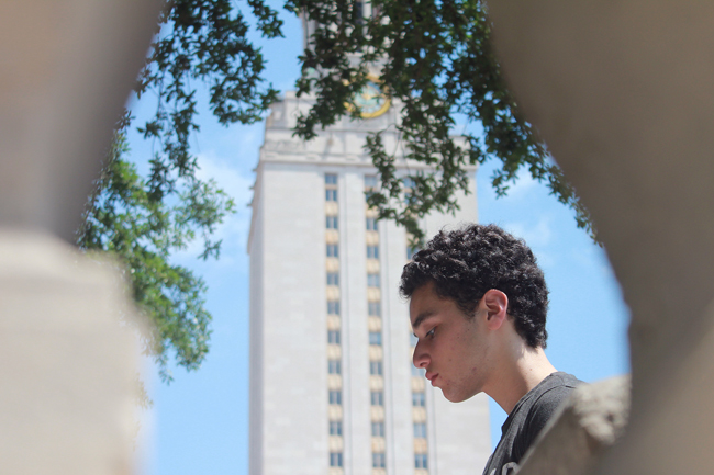 Mathematics sophomore Alec Train sits on the South Mall while Disney music plays on the Tower bells, Saturday afternoon.