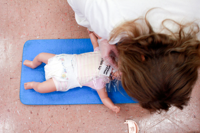 A student practices CPR on a baby doll at a CPR on a baby doll at a CPR training class held by th American Red Cross Club Saturday. The course gave citizens the opportunity to learn the life-saving technique at a discounted price.